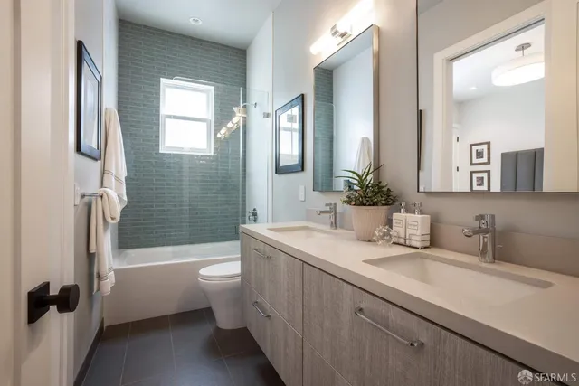 a bathroom with a double vanity sink toilet and shower