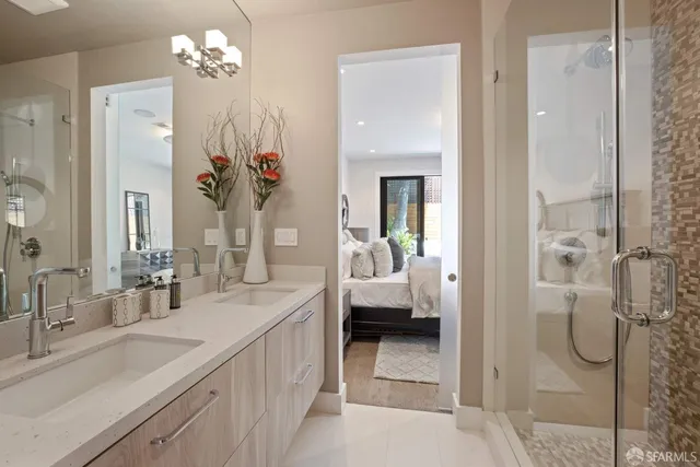 a en suite bathroom with a granite countertop sink mirror and shower