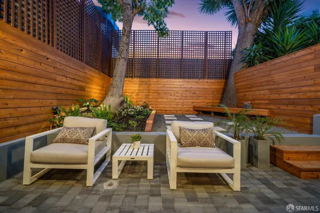 a view of a patio with a table and chairs and potted plants