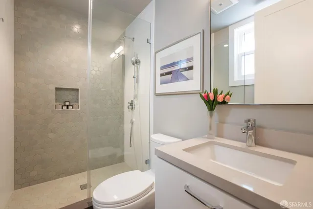 a bathroom with a sink a toilet and shower