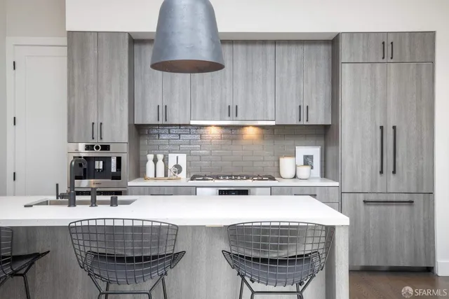 a kitchen with stainless steel appliances a sink a stove a refrigerator and cabinets