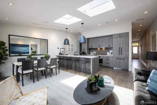 a living room with furniture kitchen and a flat screen tv