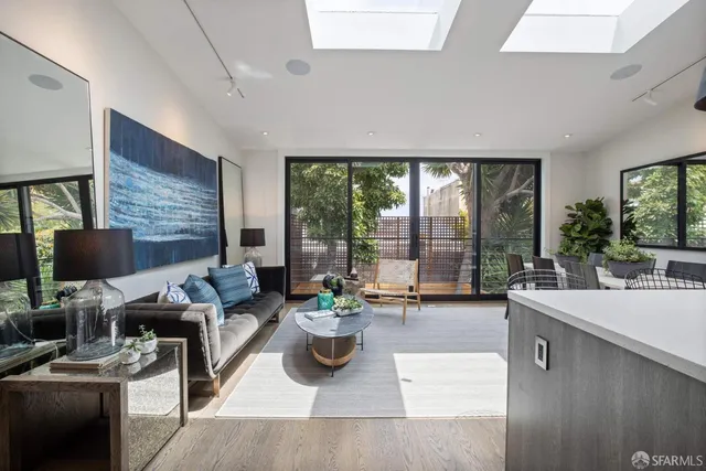 a living room with furniture potted plant and a large window