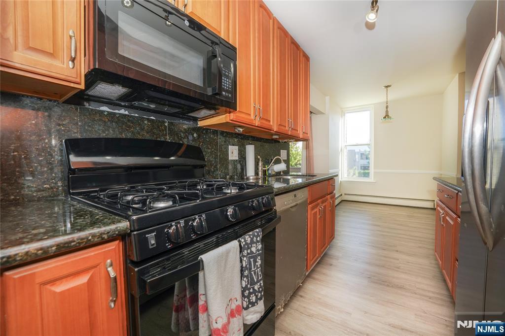 1 River, Unit 3G Nutley, NJ 07110 - Photo 15 of 27 a kitchen with stainless steel appliances granite countertop a stove a sink and a refrigerator