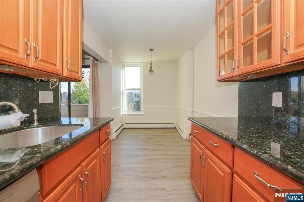 1 River, Unit 3G Nutley, NJ 07110 - Photo 16 of 27 a kitchen with stainless steel appliances granite countertop a sink and wooden cabinets with a granite countertops