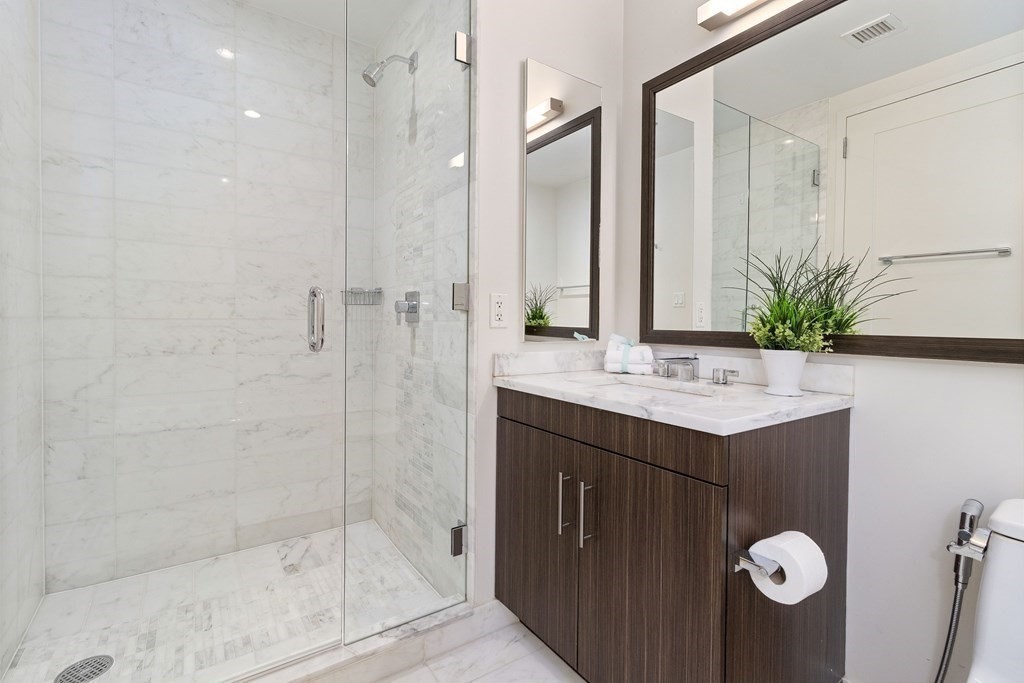 580 Washington Street, Unit 1207 Boston, MA 02111 - Photo 5 of 16 a bathroom with a sink and a mirror