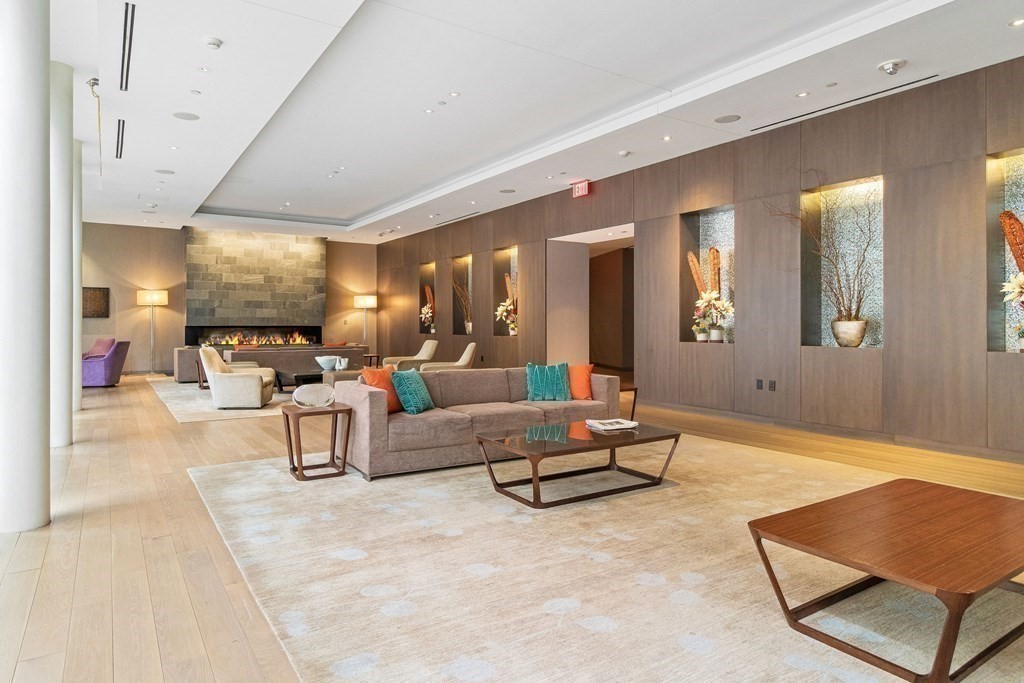 580 Washington Street, Unit 1207 Boston, MA 02111 - Photo 10 of 16 a living room with furniture and wooden floor