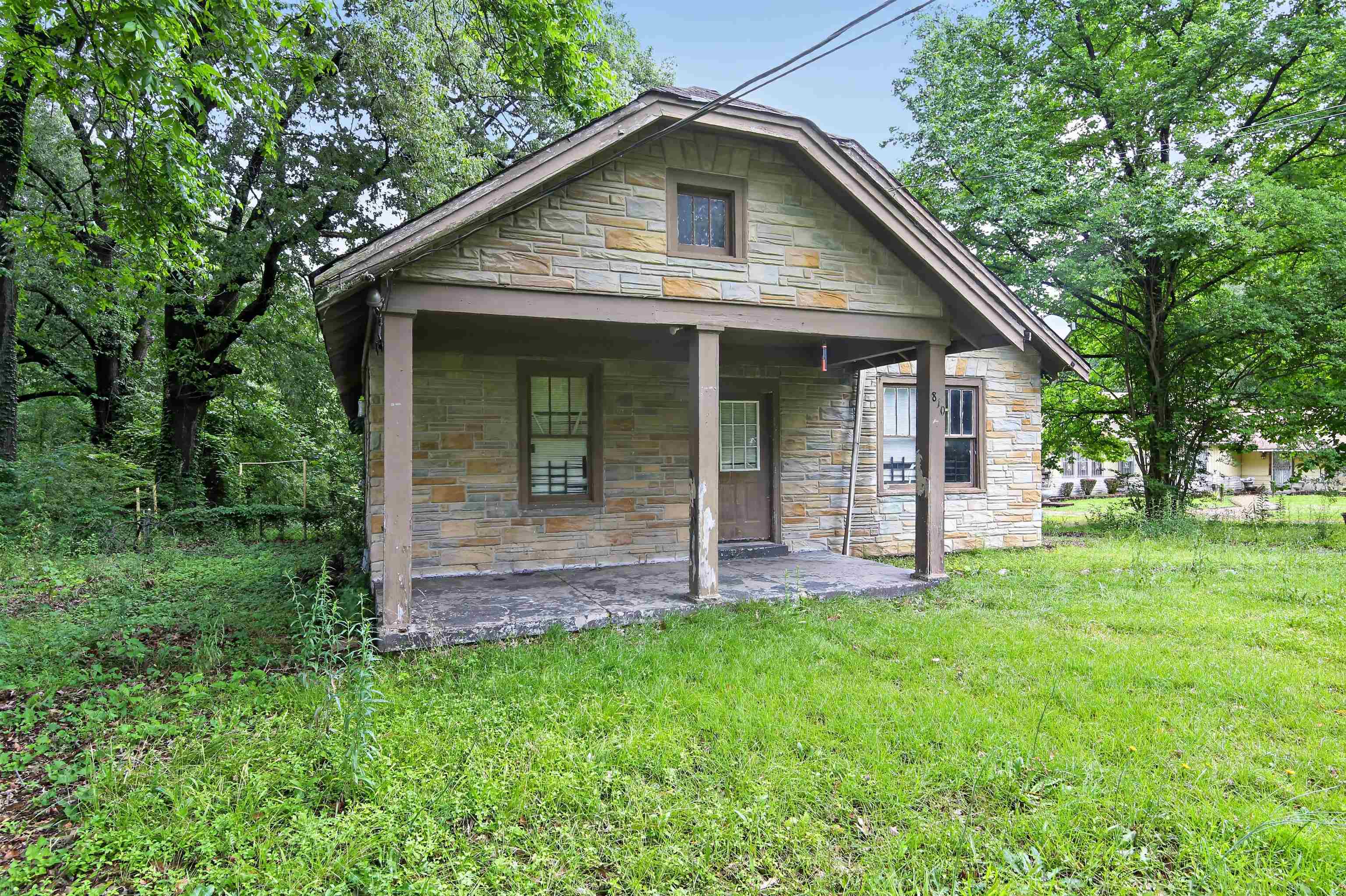 810 Hale Road Memphis, TN 38116 - Photo 5 of 30 Stone exterior home featuring a covered front porch with support columns, a gabled roof, and multiple windows