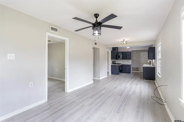 a view of a kitchen with wooden floor and a ceiling fan
