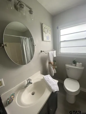 a bathroom with a toilet sink and mirror