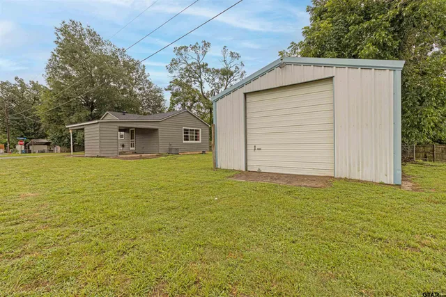 a white house that has a tree in front of it