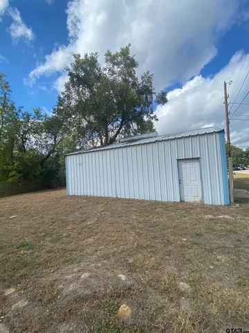 a view of backyard with wooden fence