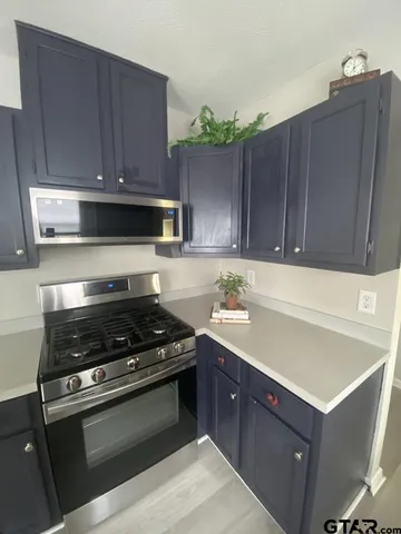 a kitchen with wooden cabinets and a stove top oven