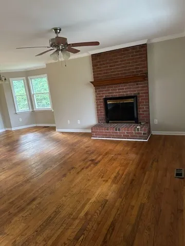 an empty room with wooden floor a fireplace