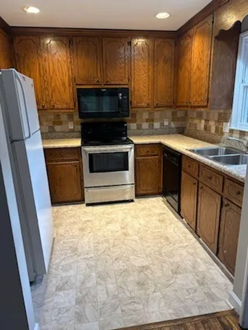 a kitchen with stainless steel appliances a stove a sink and a microwave