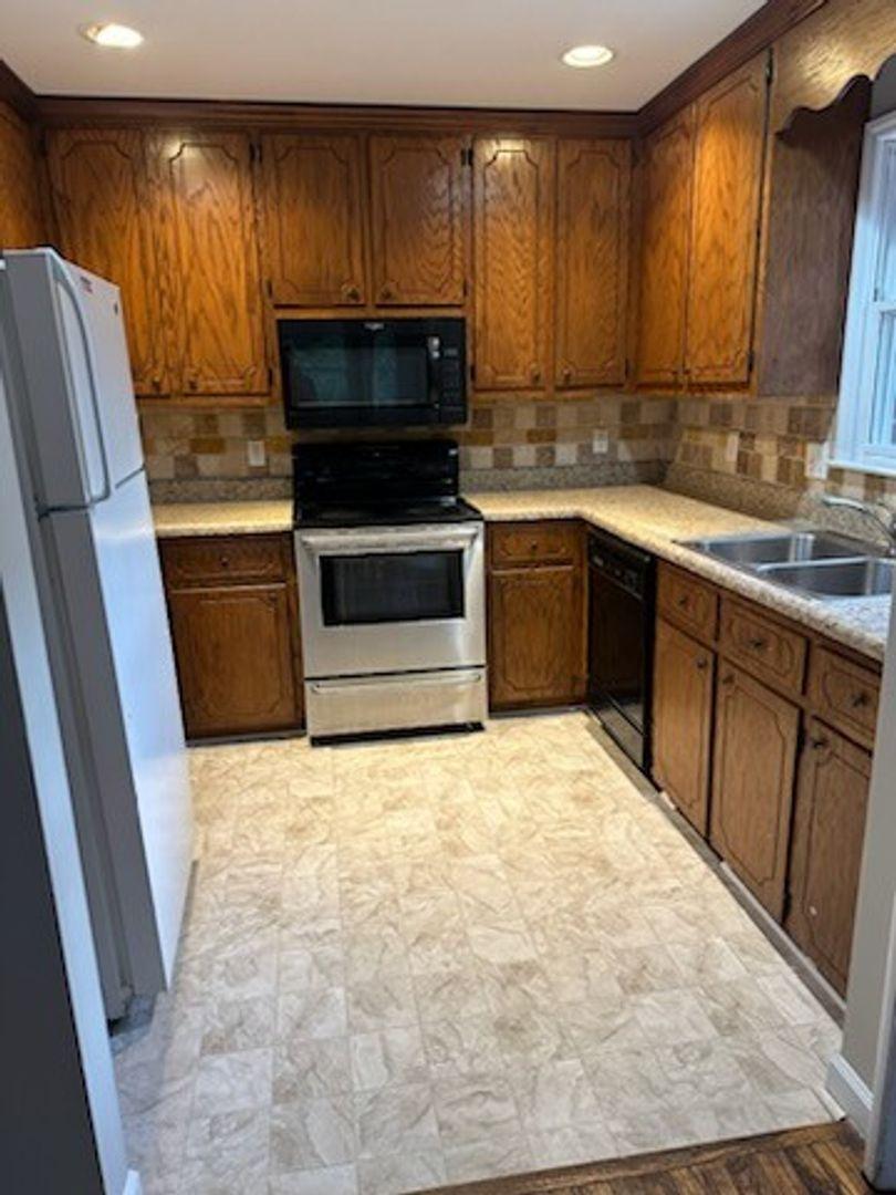 105 Starmount Road Clayton, NC 27520 - Photo 5 of 12 a kitchen with stainless steel appliances a stove a sink and a microwave