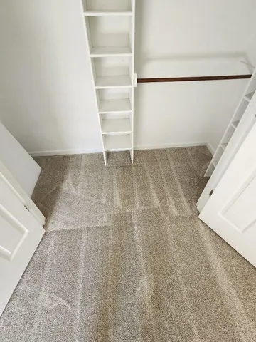 a view of walk in closet with empty racks
