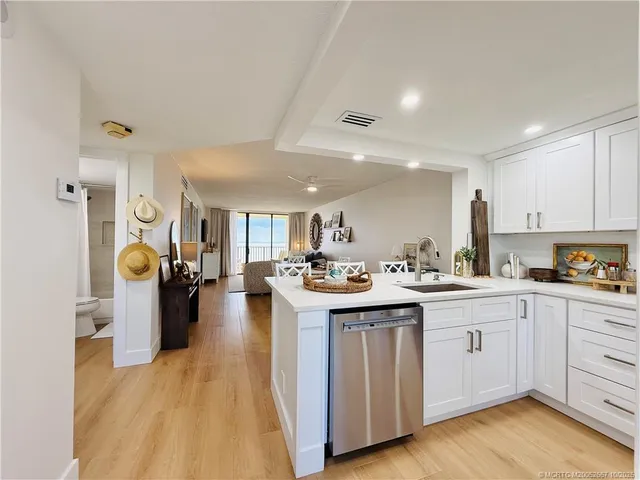 a kitchen with a sink and wooden floor