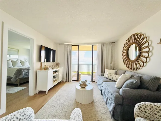 a living room with furniture a rug and a lamp