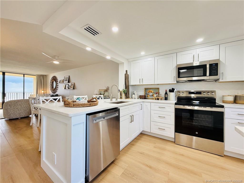 7370 South Ocean Drive, Unit 312 Jensen Beach, FL 34957 - Photo 3 of 67 a kitchen with stainless steel appliances kitchen island granite countertop a sink and cabinets