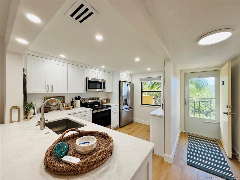7370 South Ocean Drive, Unit 312 Jensen Beach, FL 34957 - Photo 4 of 67 a kitchen with sink refrigerator and stove