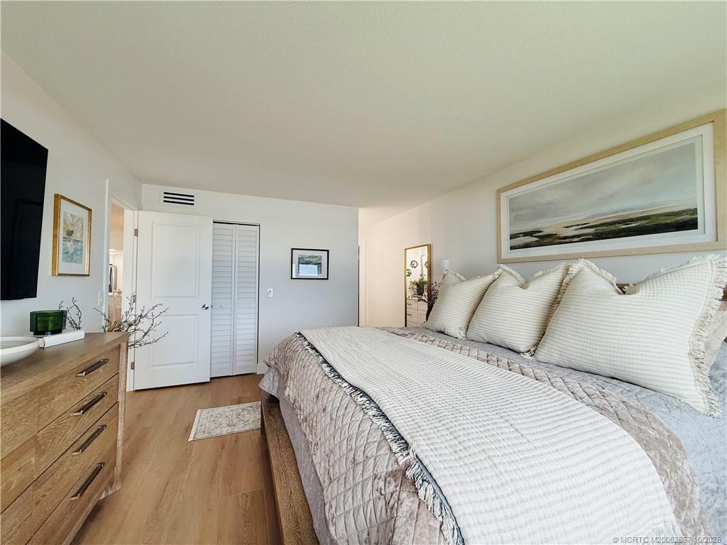 7370 South Ocean Drive, Unit 312 Jensen Beach, FL 34957 - Photo 42 of 67 a bedroom with a large bed and a flat tv screen on dresser