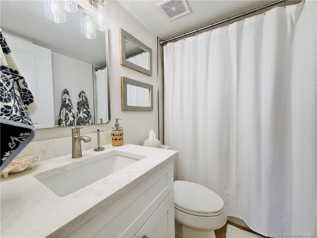 7370 South Ocean Drive, Unit 312 Jensen Beach, FL 34957 - Photo 49 of 67 a bathroom with a sink a toilet and a mirror