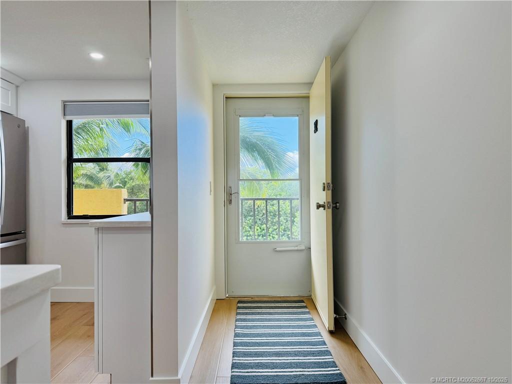 7370 South Ocean Drive, Unit 312 Jensen Beach, FL 34957 - Photo 59 of 67 a view of a hallway with wooden floor and a bathroom