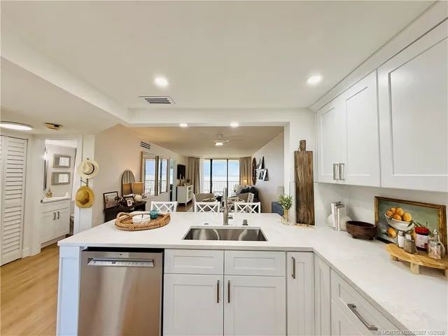 a kitchen with white cabinets and sink