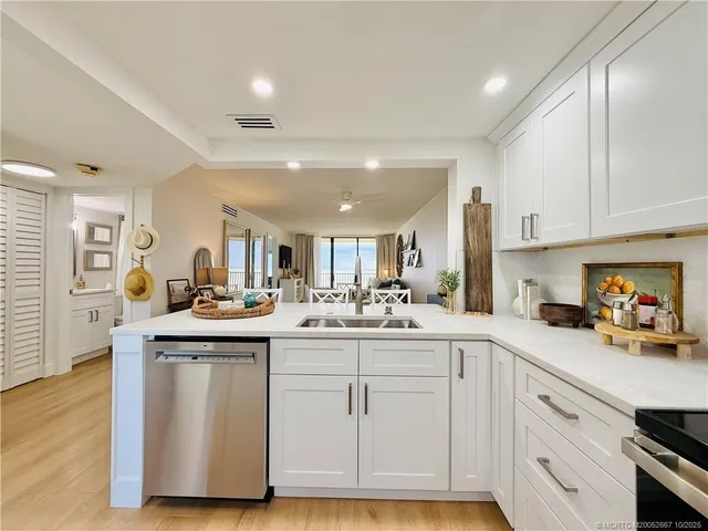 a view of a kitchen with kitchen island a large window a sink and living room view