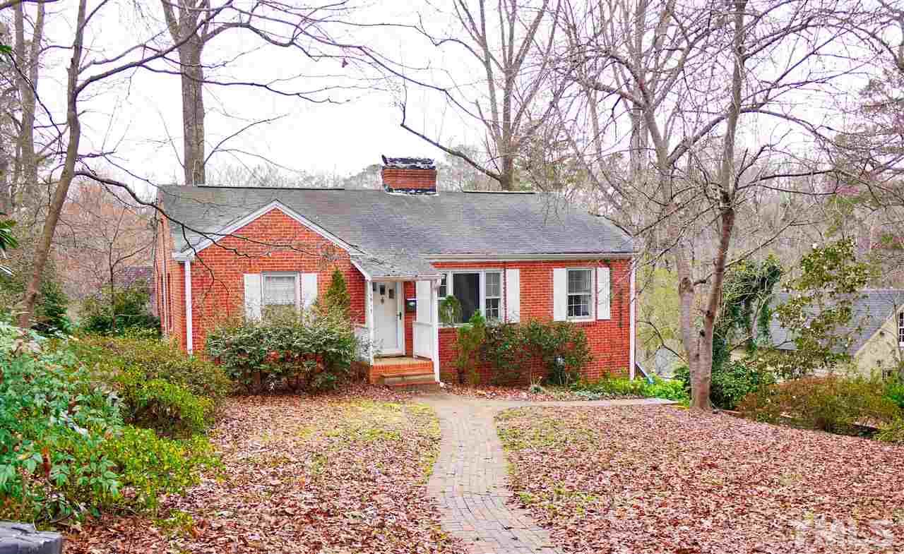 a front view of a house with yard and trees