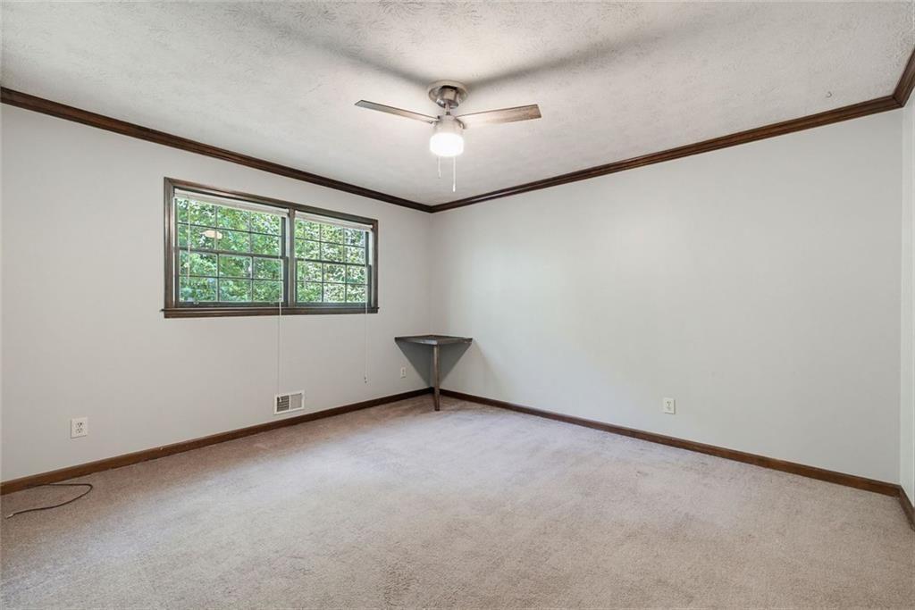 2845 Wood Forest Road Marietta, GA 30066 - Photo 18 of 26 an empty room with windows and ceiling fan
