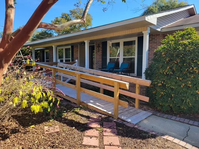 a view of a house with a large window and flower plants