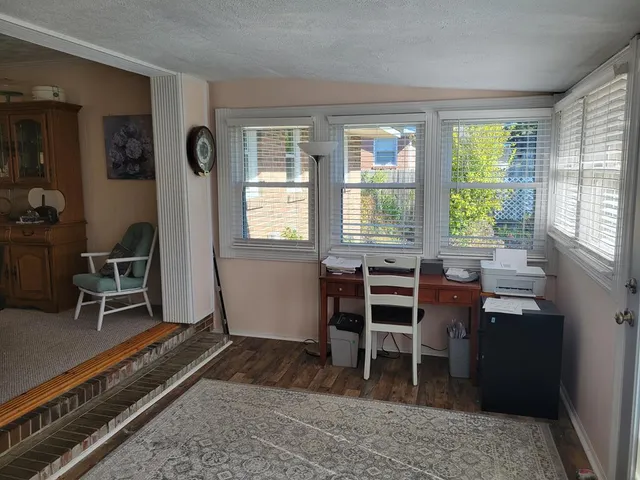 a view of a workspace with furniture and a window