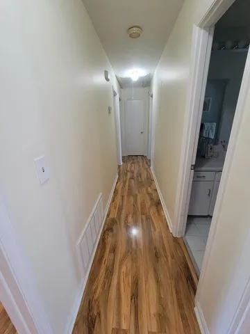 a view of a hallway with wooden floor