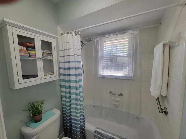 a bathroom with a shower curtain and a window
