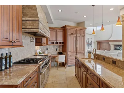 a kitchen with stainless steel appliances granite countertop a stove a sink dishwasher and cabinets with wooden floor