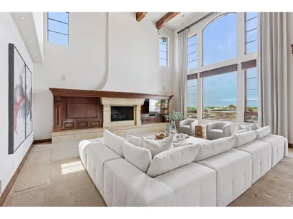 a living room with furniture fireplace and a large window