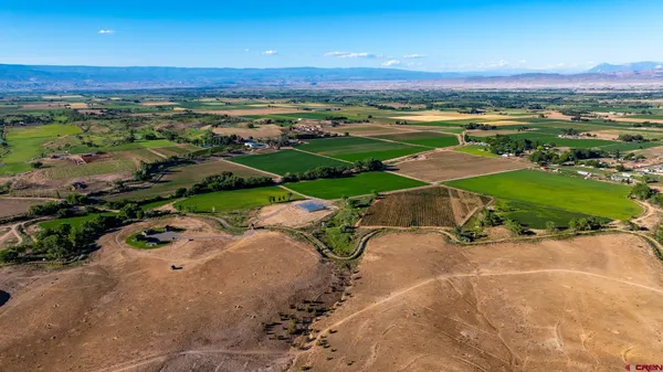 a view of a backyard with table and chairs and floor to ceiling window