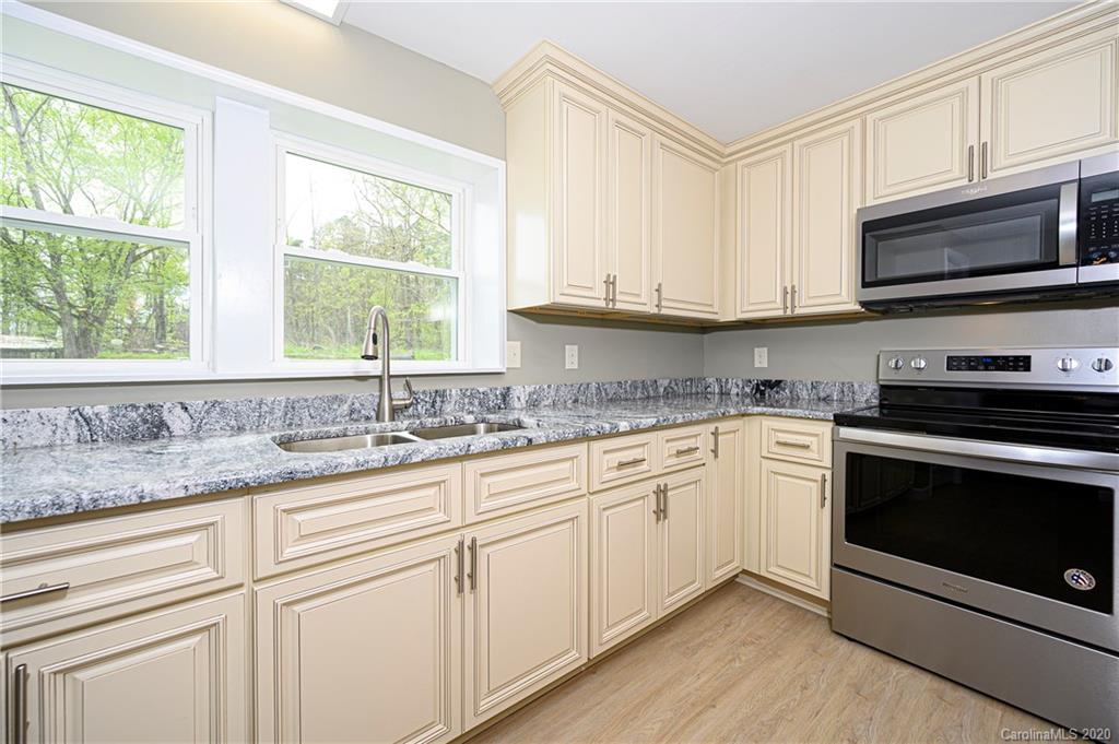 1526 Junction Road Mocksville, NC 27028 - Photo 14 of 28 a kitchen with granite countertop white cabinets a sink and a window
