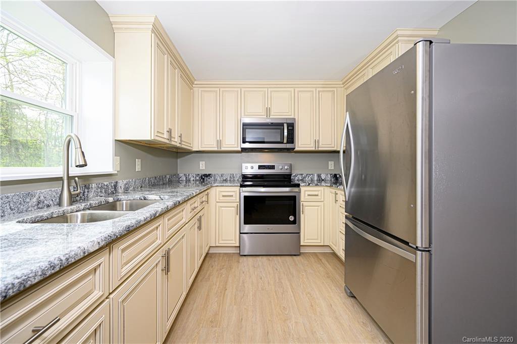 1526 Junction Road Mocksville, NC 27028 - Photo 15 of 28 a kitchen with granite countertop a refrigerator oven a sink and dishwasher with wooden floor