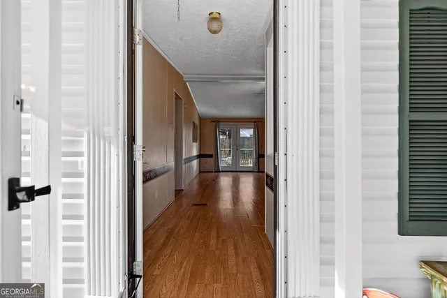 a view of an empty room with wooden floor fireplace and a window
