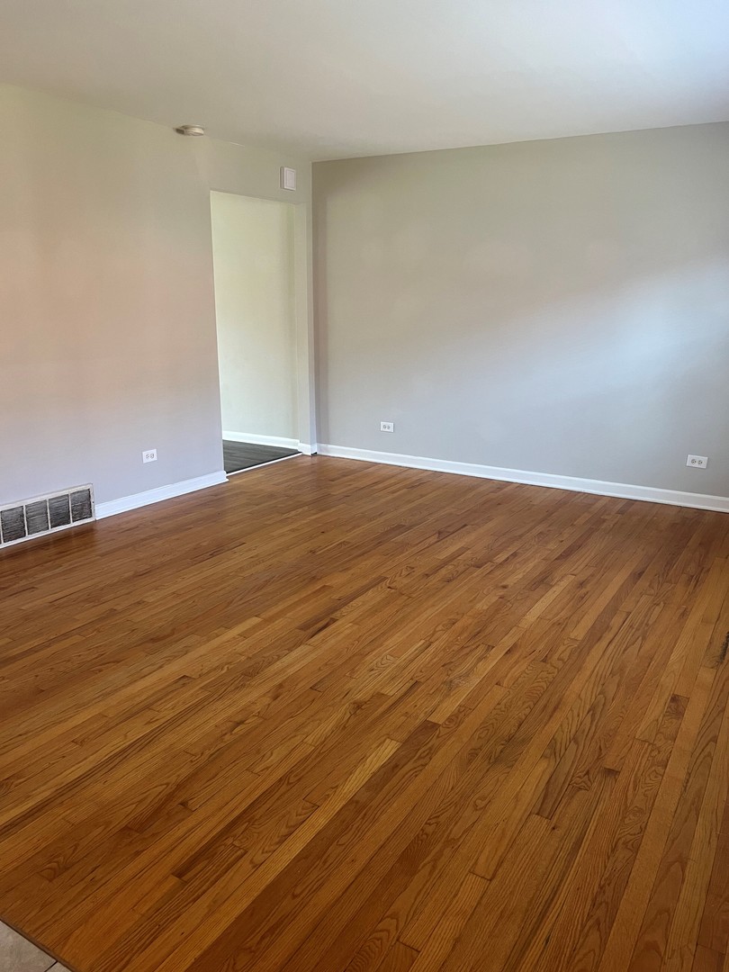 823 McHenry Road, Unit C Wheeling, IL 60090 - Photo 2 of 7 a view of an empty room with wooden floor
