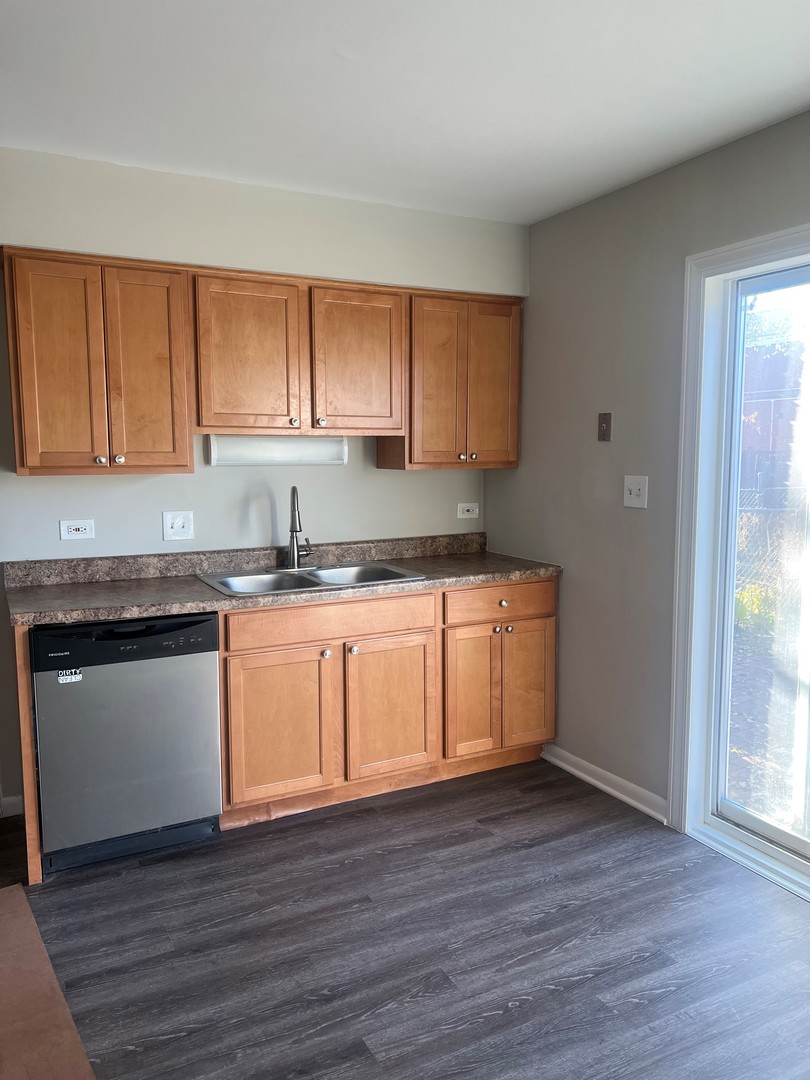 823 McHenry Road, Unit C Wheeling, IL 60090 - Photo 3 of 7 a kitchen with granite countertop wooden floors stainless steel appliances and sink