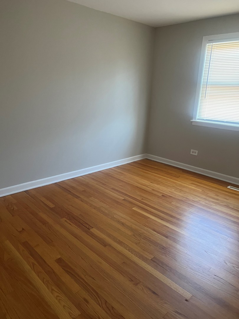 823 McHenry Road, Unit C Wheeling, IL 60090 - Photo 5 of 7 an empty room with wooden floor and windows