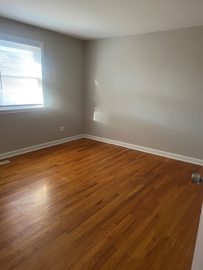 823 McHenry Road, Unit C Wheeling, IL 60090 - Photo 6 of 7 an empty room with wooden floor and windows