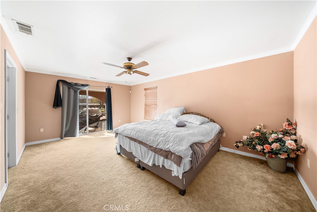 14433 Roy Rogers Road Oro Grande, CA 92368 - Photo 8 of 22 a spacious bedroom with a bed and a chandelier