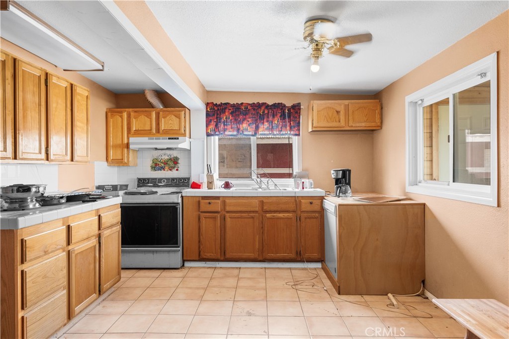 14433 Roy Rogers Road Oro Grande, CA 92368 - Photo 9 of 22 a kitchen with stainless steel appliances granite countertop a stove a sink and a refrigerator