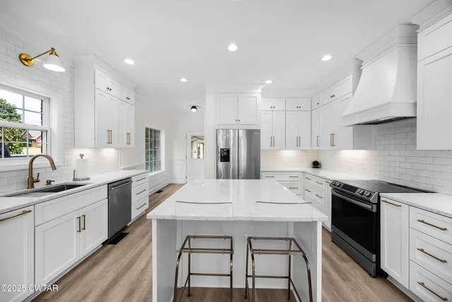 a kitchen with stainless steel appliances sink stove microwave and cabinets