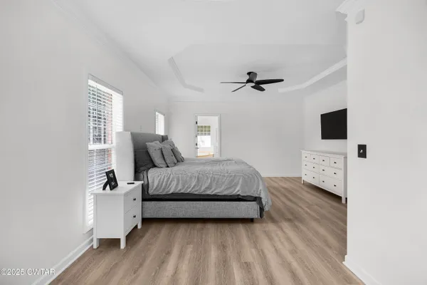 a bedroom with a bed a mirror and a flat screen tv